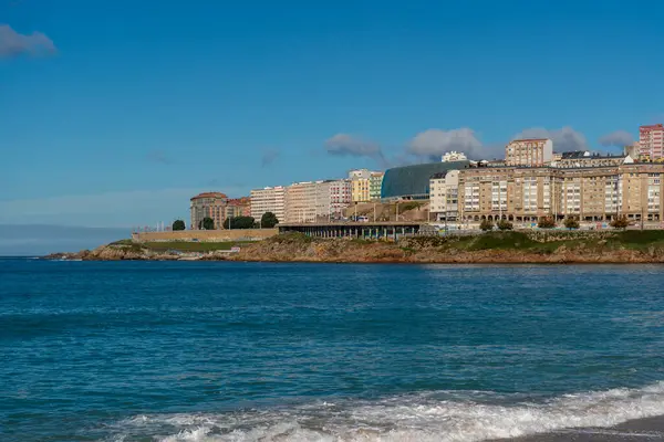 La Coruna, İspanya. 11 Kasım 2024: Orzan sahilinde mavi gökyüzü ve binalar.