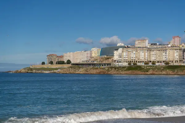 La Coruna, İspanya. 11 Kasım 2024: Orzan sahilinde mavi gökyüzü ve binalar.