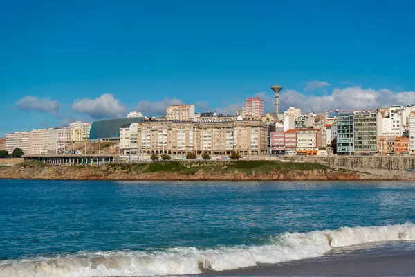 La Coruna, İspanya. 11 Kasım 2024: Orzan sahilinde mavi gökyüzü ve binalar.