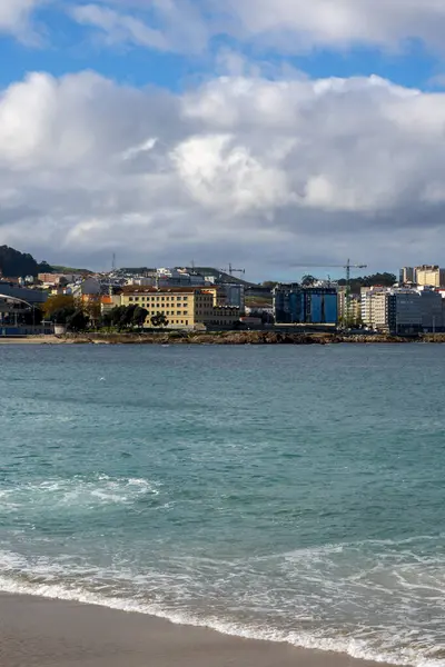 La Coruna, İspanya. 11 Kasım 2024: Orzan sahilinde mavi gökyüzü ve binalar.