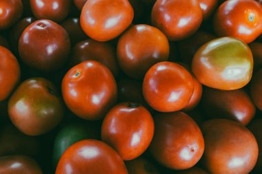 Piyasada yeşil ve kırmızı domates yığını.