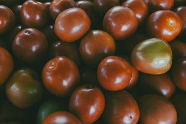 Piyasada yeşil ve kırmızı domates yığını.