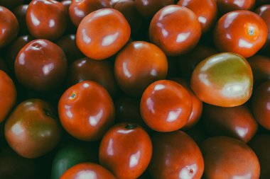 Piyasada yeşil ve kırmızı domates yığını.