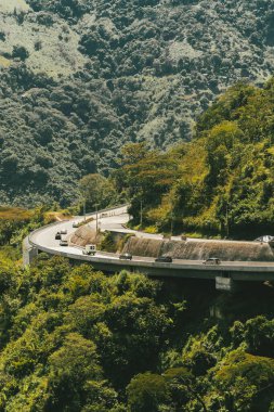 Denize giden yolda dağlar ve mavi gökyüzü olan doğa manzarası. Kolombiya.
