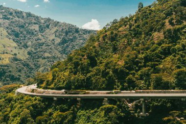 Denize giden yolda dağlar ve mavi gökyüzü olan doğa manzarası. Kolombiya.