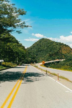 Denize giden yolda dağlar ve mavi gökyüzü olan doğa manzarası. Kolombiya.