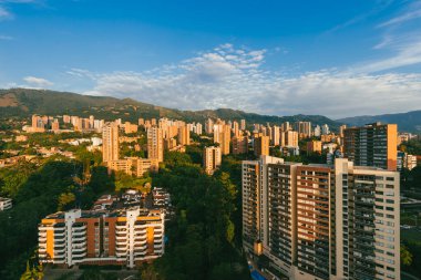 Medellin, Antioquia, Kolombiya. 27 Ağustos 2024: Mavi gökyüzü ve doğu manzaralı kasabadan panoramik manzara.