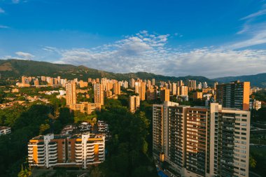 Medellin, Antioquia, Kolombiya. 27 Ağustos 2024: Mavi gökyüzü ve doğu manzaralı kasabadan panoramik manzara.