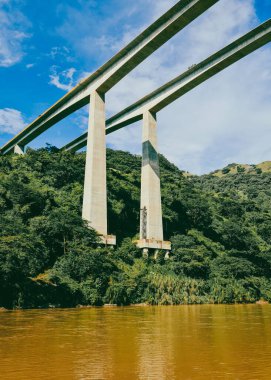 Cauca Nehri Köprüsü. Pasifik Otoyolu ve mavi gökyüzü. Antioquia, Kolombiya.