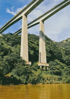 Cauca Nehri Köprüsü. Pasifik Otoyolu ve mavi gökyüzü. Antioquia, Kolombiya.