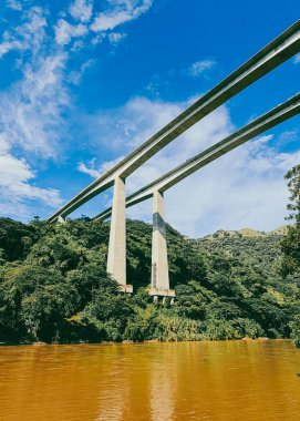 Cauca Nehri Köprüsü. Pasifik Otoyolu ve mavi gökyüzü. Antioquia, Kolombiya.