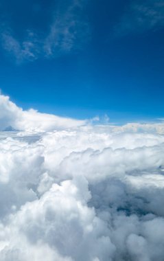 Bir uçak penceresinden bulutların yükseldiği güzel gökyüzü manzarası.