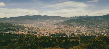Panoramic landscape of Medellin - Valle de Aburra. Green mountains and beautiful blue sky. Colombia.