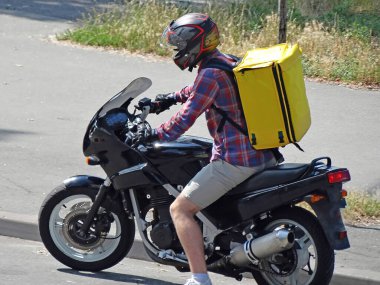 Pembe forma üniformasının teslimatçısı motosikleti internetten sipariş veren müşterilere teslim etmek için kullanıyor..