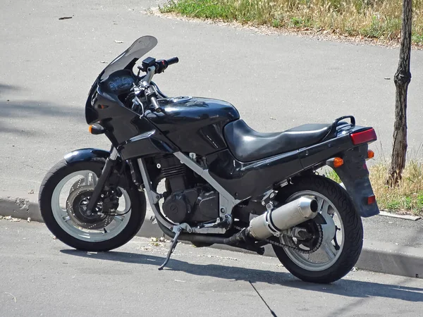 黒のスポーツオートバイの道路上の背景都市の大学に立って — ストック写真