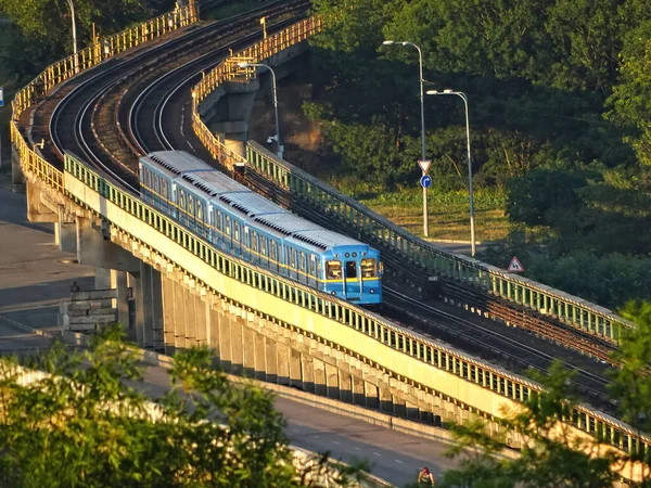 Surface metro. Modern train moving on rails above the ground in the city. Subway cars traveling across the bridge, outdoors. New public rapid transit