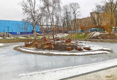 Houses for birds on the lake in winter. Many small lake houses for waterfowl. Swan houses. Duck houses for the winter. Bird house on the water. Kharkov zoo. 21.03.22, Kharkiv, Ukraine