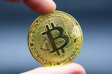 Finger hold bitcoin golden on black isolated. Hand hold gold bitcoin crypto ditital money concept. On a black background we look at a virtual currency, namely the cryptocurrency bitcoin, held in the right mine photo