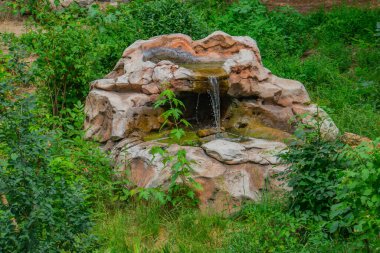 Granit taşlardan yapılmış küçük yapay şelale. Eyalet parkında yapay kayadan yapılmış bir şelale. Nehirdeki kayalardan akan soğuk dağ suyu açık havada. Peyzaj tasarımı.