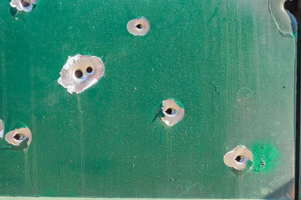 bullet holes in the metal. multiple bullet marks on the car body. peeling green. bullet holes, texture, metal, shooting, shooting on the street, shot, target, bullet, grapeshot, gunpowder, background