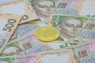 500 Ukrayna Hryvnia banknotunun arka planında altın bitcoin. Ukrayna 'da Bitcoin. Bitcoin değişimi. Ukrayna para birimine Bitcoin döviz kuru. Ukrayna 'da engelleme teknolojisi kullanımı.