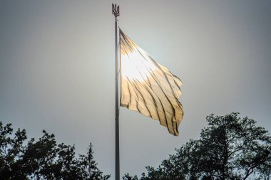 Ukrayna amblemi. Mavi gökyüzünde dalgalanan Ukrayna bayrağı. Büyük sarı Ukrayna bayrağı. Ulusal Ukrayna bayrağı mavi gökyüzüne karşı. Ukrayna bayrağının ayrıntıları. Ukrayna Amblemi