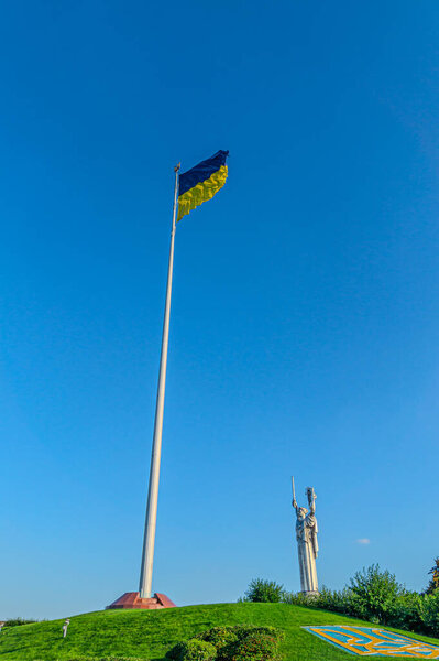 Emblem of Ukraine. Ukraine flag large national symbol fluttering in blue sky. Large yellow blue Ukrainian state flag. National flag of Ukraine against blue sky. Detail of the national flag of Ukraine. Emblem of Ukraine