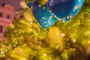 Kalp şeklindeki süslerle süslenmiş bir Noel ağacının arka planı. Sarı altın ışıklı Noel ağacı süslemesi