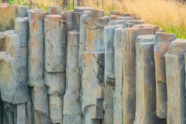 Eski taş tuğla duvardaki yakın yüzey tuğla deseni siyah beyaz tonda. Parktaki taş duvar. Çevredeki taş duvarlar duvardan sarkan kaya parçaları.