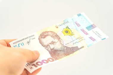 Beyaz arka planda izole edilmiş 1000 Hryvnia. Maksimum Ukrayna mezhebine sahip banknot. Ukrayna nakit parası kavramı. Ukrayna 'da nakit ödeme. Bir adamın eli Ukrayna parasıyla öder.