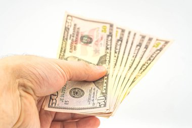 Elinde birkaç tane 50 dolarlık banknot var. Beyaz arka planda izole edilmiş dolarları olan bir adam. İş adamı elli dolar verir. Amerika 'da bahşiş ve nakit kavramı. Bir tomar dolar, rüşvet, yasadışı trafik.