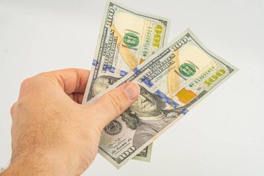 El ele tutuşan para beyaz arka planda izole. Ödeme ve verme için 100 dolarlık banknot. İş ve Finans konsepti. 100 dolar nakit para. Paralı eller Amerikan doları.