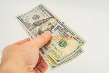 El ele tutuşan para beyaz arka planda izole. Ödeme ve verme için 100 dolarlık banknot. İş ve Finans konsepti. 100 dolar nakit para. Paralı eller Amerikan doları.
