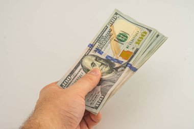 El ele tutuşan para beyaz arka planda izole. Ödeme ve verme için 100 dolarlık banknot. İş ve Finans konsepti. 100 dolar nakit para. Paralı eller Amerikan doları.