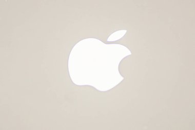 Titanyum arka planda beyaz elma logosu. Yakın çekim yüksek çözünürlüklü. Elma logolu alüminyum bilgisayar materyali. Cep telefonunda Apple logosu. Kiev, Ukrayna 01-29-2024