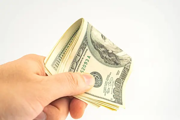 Hand holding money isolated on white background. One hundred Dollars bill on man hand to paying and giving. Business and Finances concept. 100 Dollars Cash Money. Hands with money American dollars.