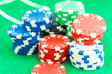 Oyun masasında poker fişleri. Pokerde kazanan kombinasyonlu bir zar siyah masa üzerinde ve arka planda çipler