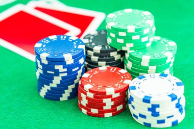 Oyun masasında poker fişleri. Pokerde kazanan kombinasyonlu bir zar siyah masa üzerinde ve arka planda çipler
