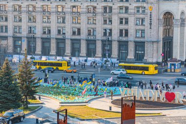 ATO, Stalin ve modern mimari KIEV, UKRAINE 05-04-2024 tarihli fotoğraf sergisi, Stella, Institutskaya Caddesi 'ndeki Independence Meydanı arka planının Akşam Görüşü üzerine otobüsler.