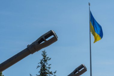 Bir Ukrayna bayrağı ve silah ağzı. Rus-Ukrayna savaşı kavramı. Ukrayna savunması. Ukrayna için silah ve yardım.