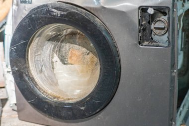 Hasarlı çamaşır makinesini kontrol eden kadın, dairedeki yangından sonra zemini su basmış, çamaşır makinesi bozulmuş..