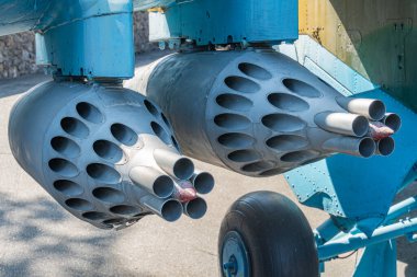 Bir uçağın kanadı altında asılı duran hava bombası. Helikopterin kanat ucunda boş roket fırlatıcısı olan roket kapsülü. Kontrolsüz uçak bloğu