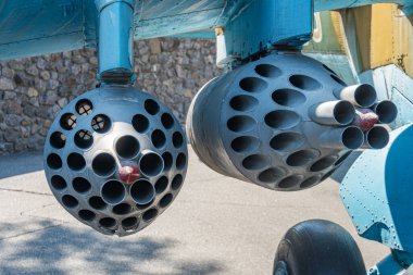 Bir uçağın kanadı altında asılı duran hava bombası. Helikopterin kanat ucunda boş roket fırlatıcısı olan roket kapsülü. Kontrolsüz uçak bloğu