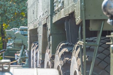 Askeri tekerler yaklaşıyor, askeri teçhizat taşınıyor. Topçu birliklerinin araçları yürüyüş, ulaşım ve geçit töreninde. Silahın bir kısmı yakın planda. Rus-Ukrayna savaşı