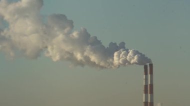 Elektrik santralinin iki bacası beyaz duman ve atmosfer kirliliği yayıyor. Küresel Isınan Adam 'ın Karbon Ayak İzi. Fosil yakıt kavramına sahip elektrik üretimi. Kirletici