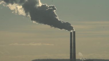 Elektrik santralinin iki bacası beyaz duman ve atmosfer kirliliği yayıyor. Küresel ısınma Mans Karbon Ayak İzi. Fosil yakıt kavramına sahip elektrik üretimi. Kirletici.