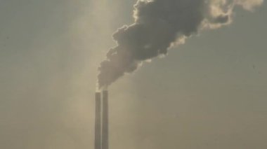 Elektrik santralinin iki bacası beyaz duman ve atmosfer kirliliği yayıyor. Küresel ısınma Mans Karbon Ayak İzi. Fosil yakıt kavramına sahip elektrik üretimi. Kirletici.