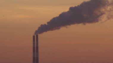 Elektrik santralinin iki bacası beyaz duman ve atmosfer kirliliği yayıyor. Küresel ısınma Mans Karbon Ayak İzi. Fosil yakıt kavramına sahip elektrik üretimi. Kirletici.