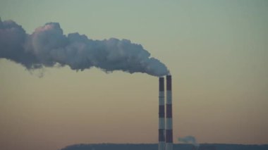 Elektrik santralinin iki bacası beyaz duman ve atmosfer kirliliği yayıyor. Küresel ısınma Mans Karbon Ayak İzi. Fosil yakıt kavramına sahip elektrik üretimi. Kirletici.