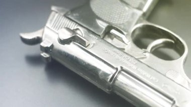 Masanın üzerinde bir silah yatıyor. Suç kavramı. Yakından bakınca, bir suç programının ekran koruyucusu. Kuzgun çeliği yansıması ve parıltısı. Karanlık arka planda cephanesi olan bir silah.